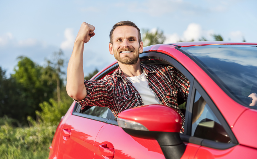 A man happy in car after saving on car insurance with wetrust.co.uk